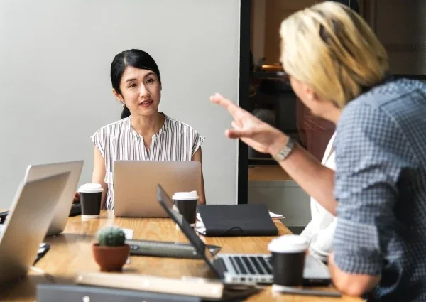 Professionals collaborating around laptops during a small business meeting