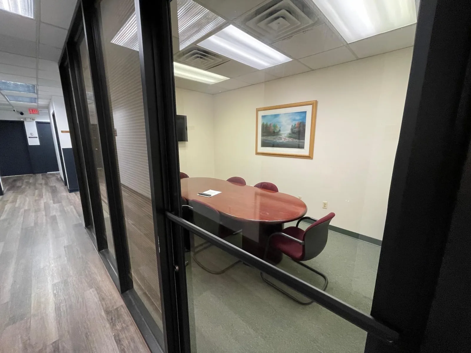 Conference room with oval table viewed from the hallway