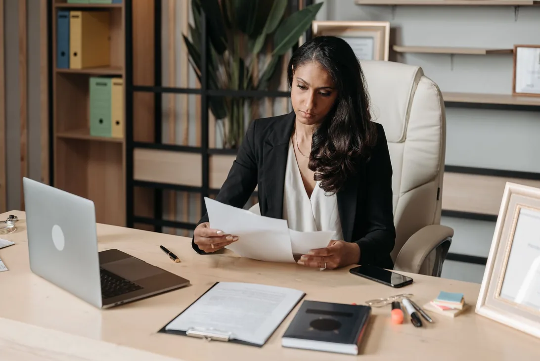 Professional woman reviewing business documents in a modern office