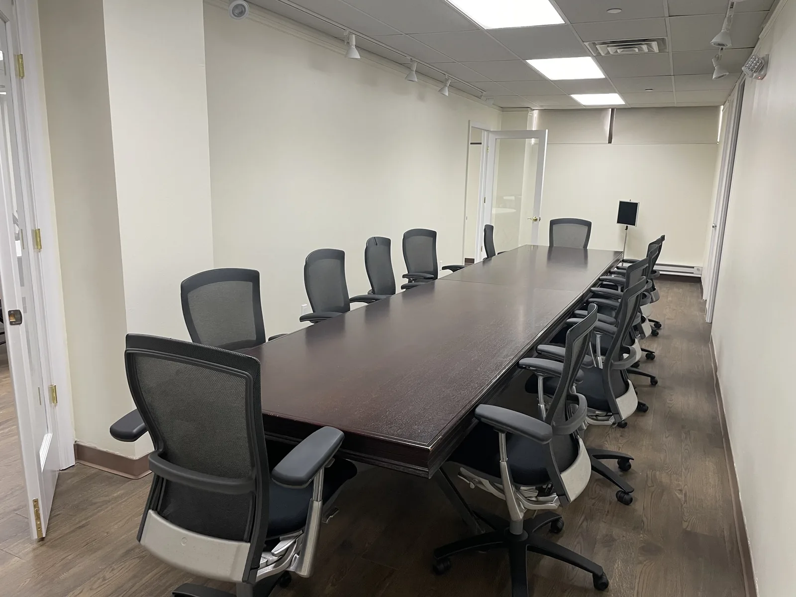 Large boardroom with a long conference table and high-back office chairs