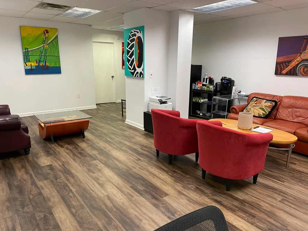 Client lounge with colorful seating, local artwork and coffee station