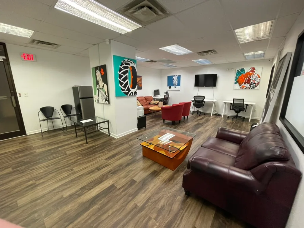 Furnished shared lounge with artwork, seating and workstations