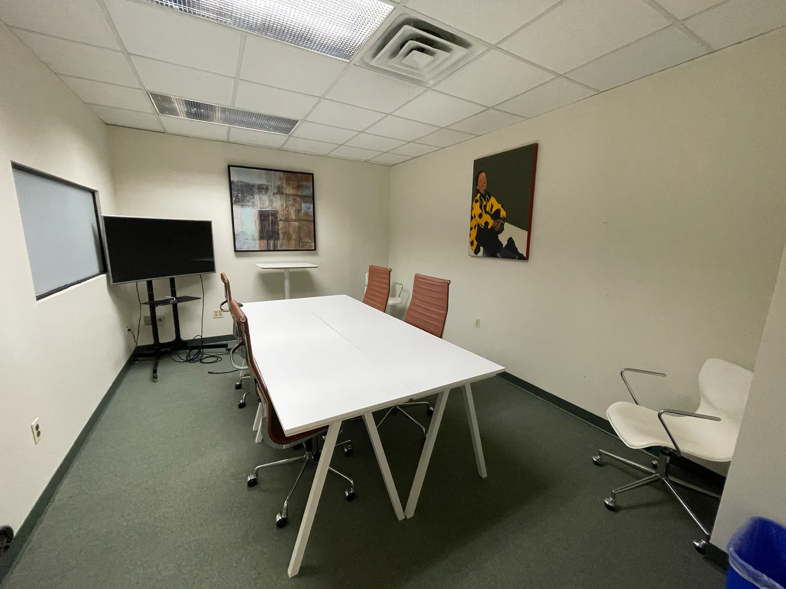 Conference room with meeting table, presentation screen and guest chairs