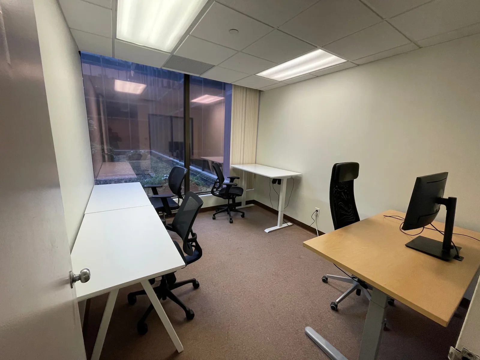 Furnished private office with desks and computer monitors