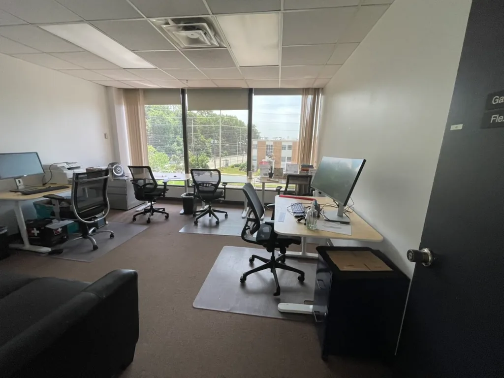 Daylit team office with desks, monitors and large windows